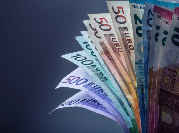 Ruka drží stoh európskych bankoviek.