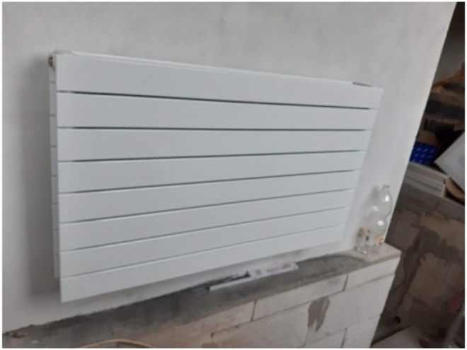 Nový biely hliníkový radiator na stene